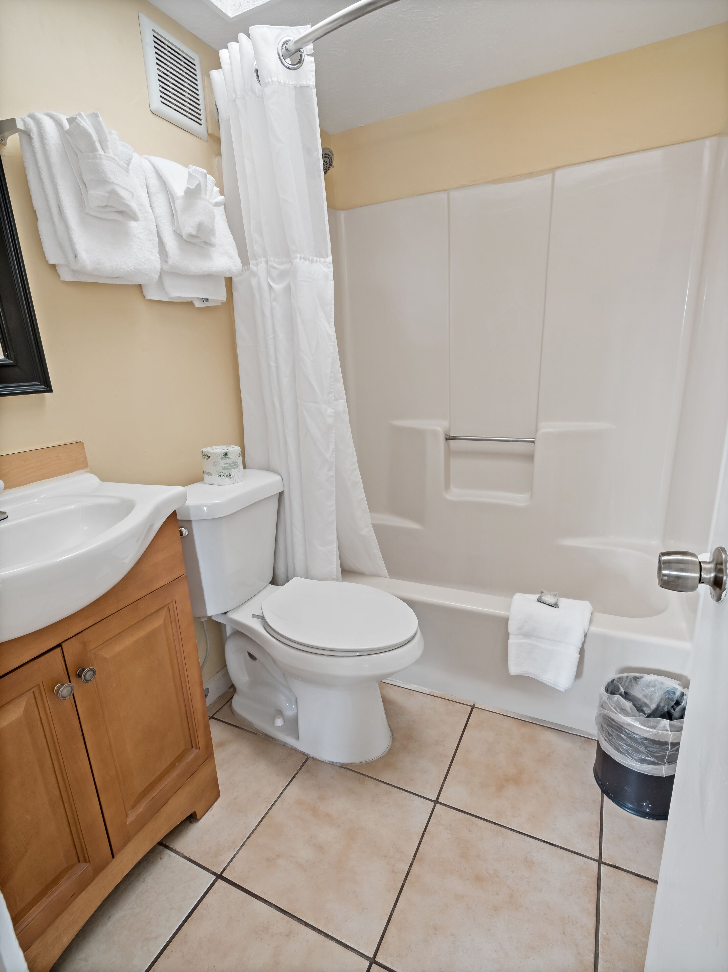 A bathroom with a toilet, sink, and bathtub.