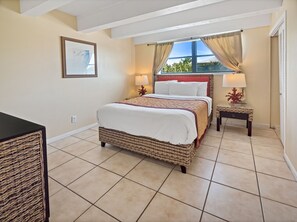 Relax in a spacious bedroom with a large, comfortable bed and a view of the outdoors.