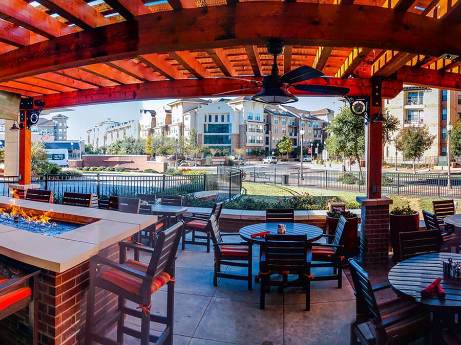 An outdoor patio area with a fire pit, tables, and chairs.