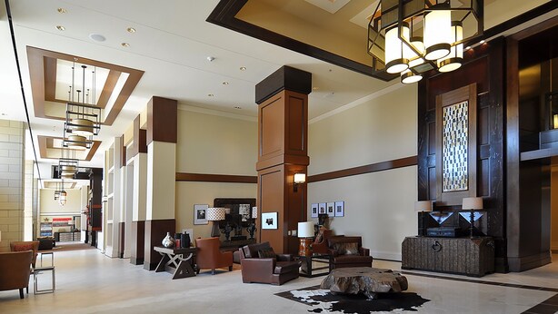 A spacious lobby with a high ceiling, modern lighting fixtures, and comfortable seating areas. - Overton Hotel and Conference Center (Lubbock)