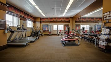 A gym with treadmills, elliptical machines, and free weights.