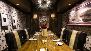 A conference room with a long wooden table, black leather chairs, and a large wall-mounted screen. - Overton Hotel and Conference Center (Lubbock)