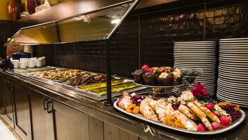 A buffet with various food items and a rose decoration.