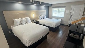 A hotel room with two beds, a desk, and a window. - Travelodge by Wyndham Ukiah (Ukiah)