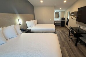 A hotel room with two beds, a desk, a chair, a TV, and a mirror. - Travelodge by Wyndham Ukiah (Ukiah)