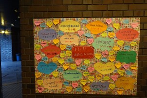 Una pared cubierta de notas adhesivas de colores en varios idiomas, lo que sugiere un ambiente multilingüe o un lugar de interés internacional.