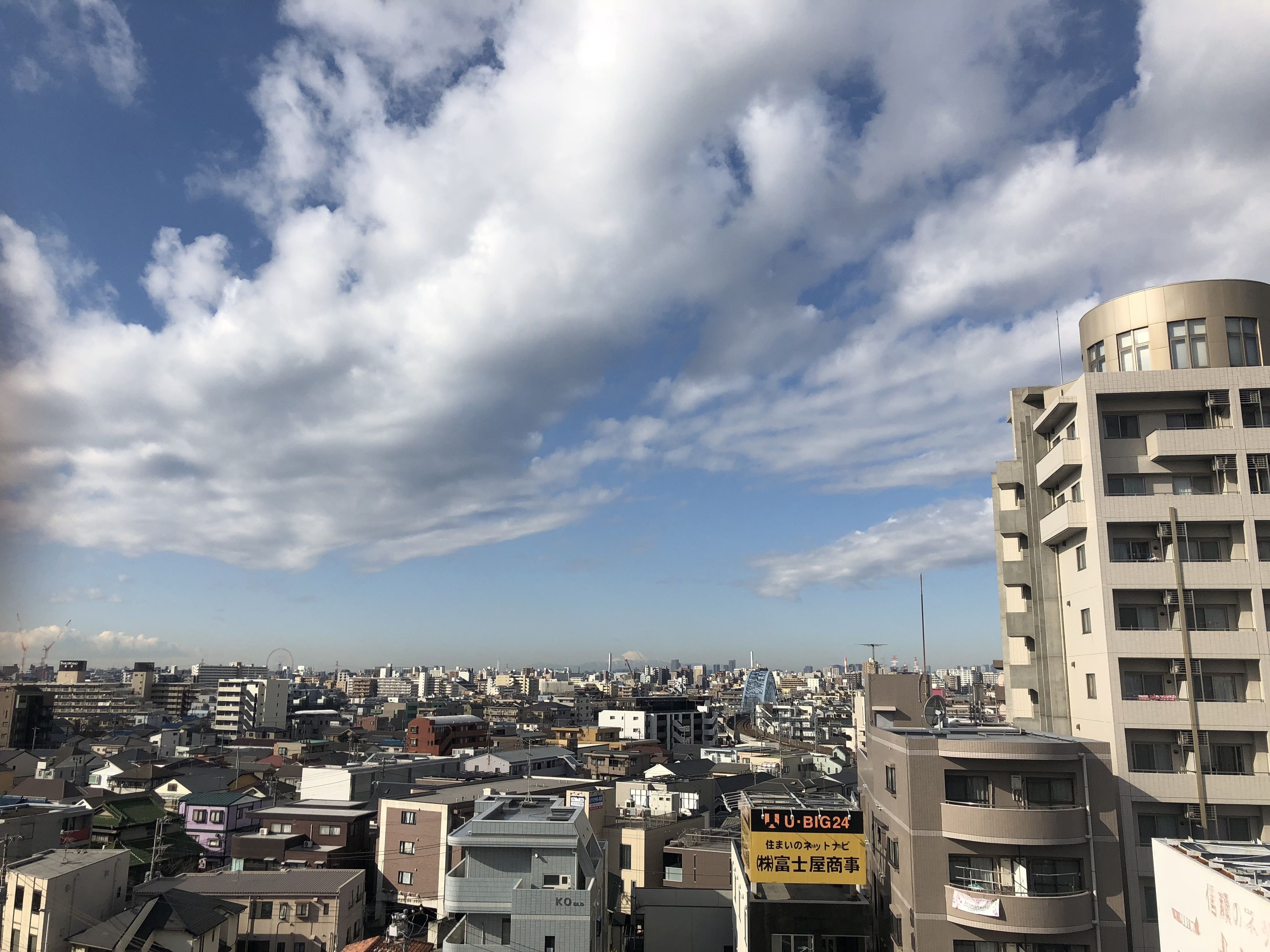 Un paisaje urbano con una combinación de edificios residenciales y comerciales, incluyendo un edificio destacado con un letrero que dice 