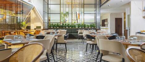 A modern dining area with high ceilings, large windows, and a central seating area.