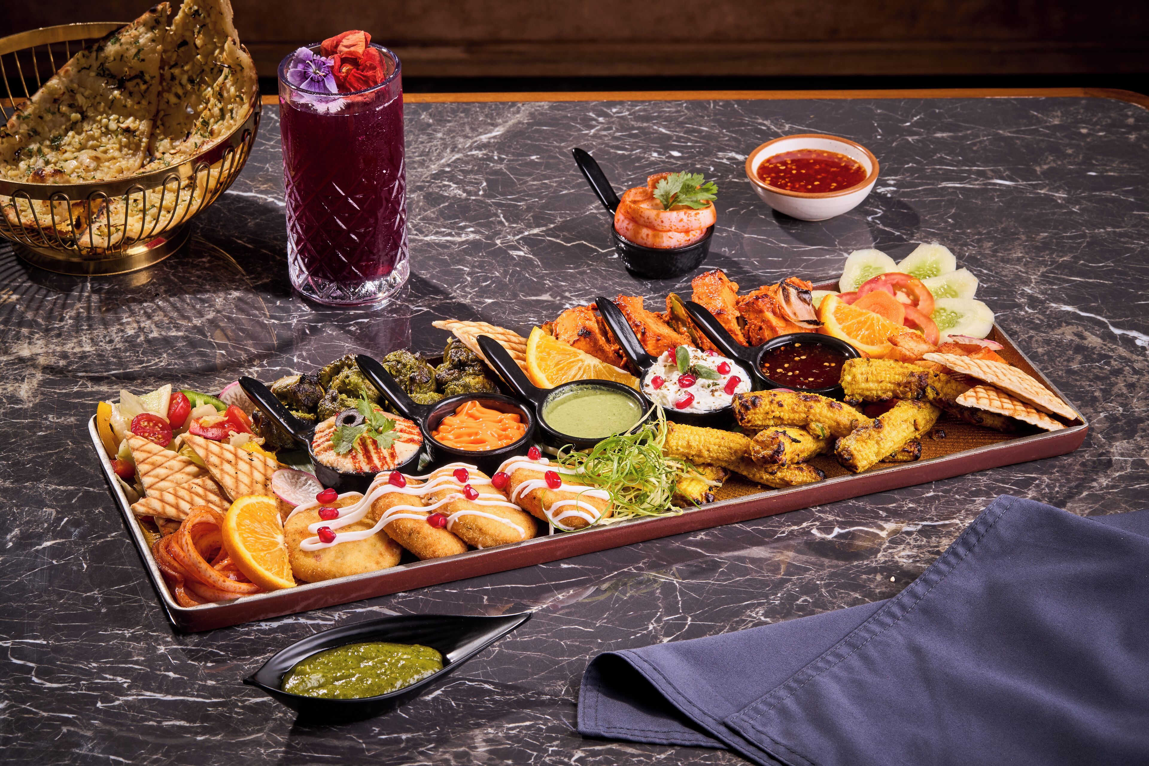 A variety of appetizers and drinks on a marble table.