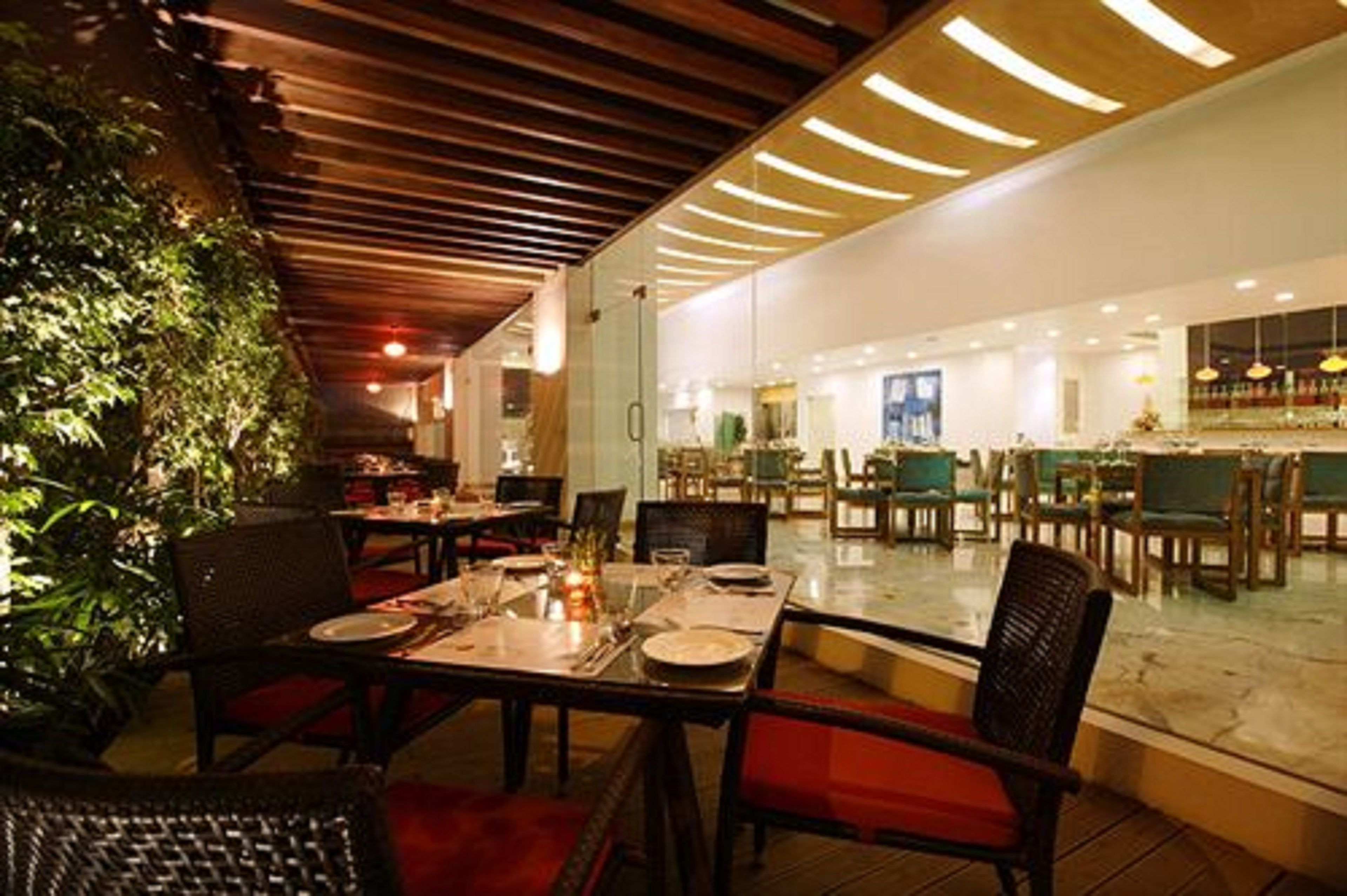 A restaurant with tables set for dining, a bar area, and a view of the outdoors.