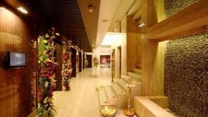 Un corridoio con decorazioni floreali, una reception e un muro con motivo strutturato.