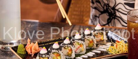 A variety of sushi on a tray, a glass of iced tea, and a bowl of soup.