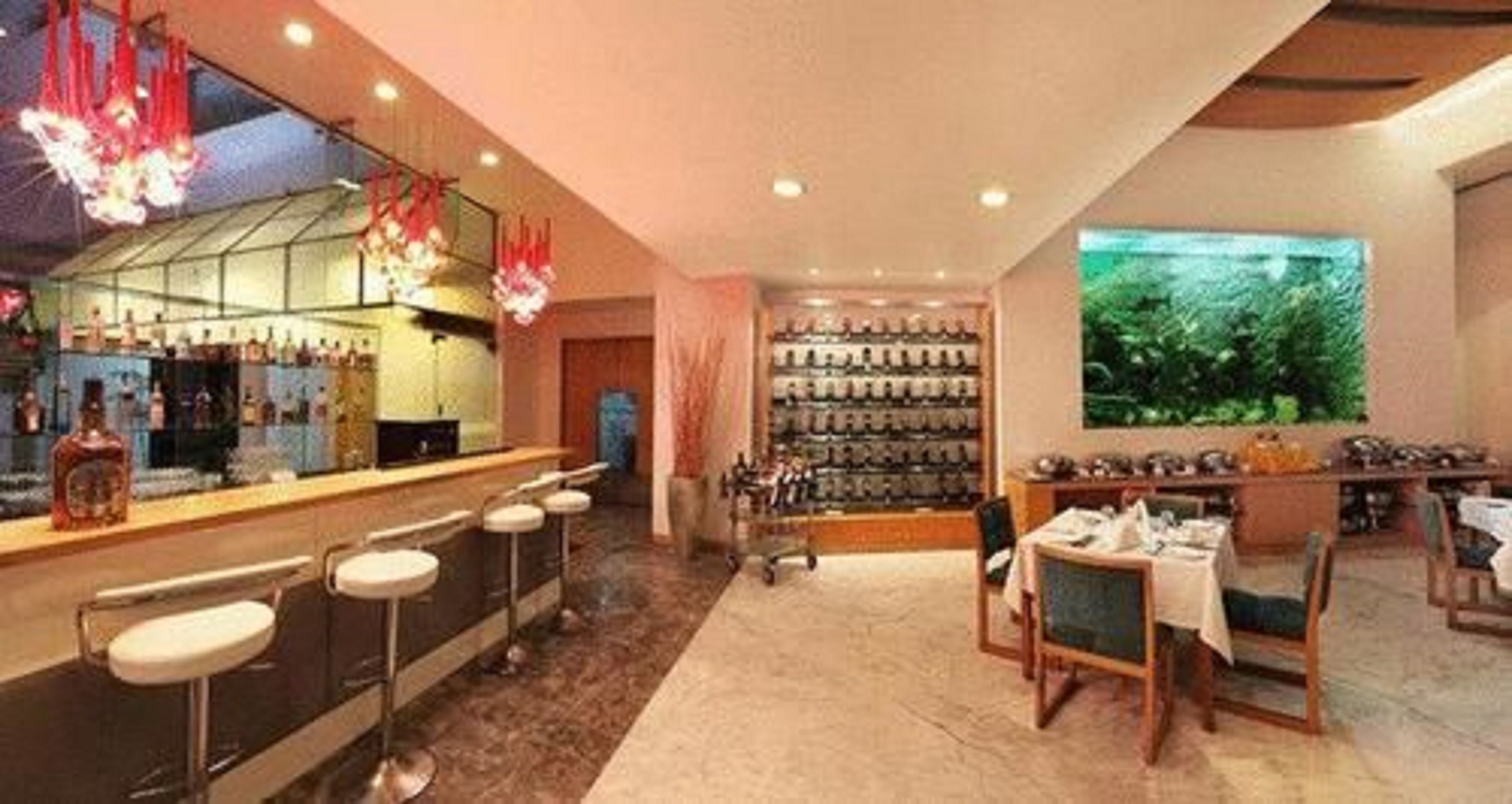 Zona de bar con taburetes, mostrador y un gran acuario.