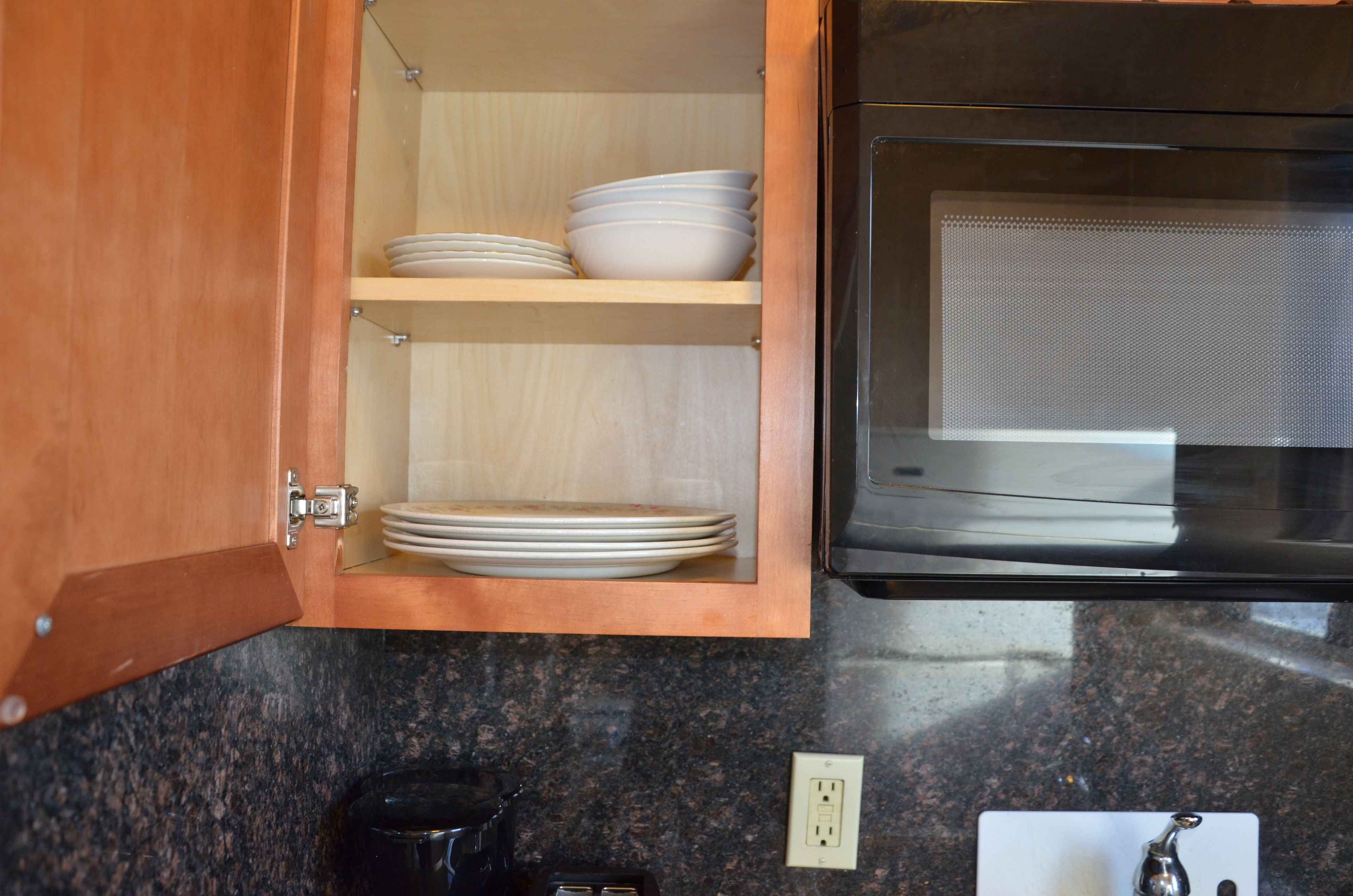 Una cocina con armarios de madera, microondas y cafetera.