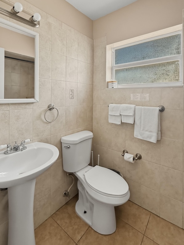 A bathroom with a sink, toilet, and a window with a view. - La Terrace Oceanfront (Hollywood)