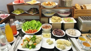Una mesa de buffet con diversos alimentos, incluyendo frutas, verduras y salsas.