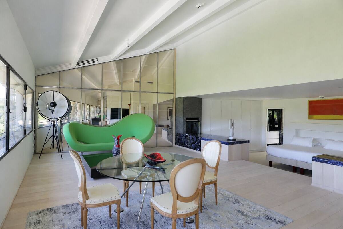 Een moderne woonkamer met een groene bank, een glazen salontafel en een witte bank.