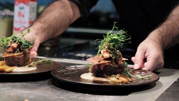 A chef placing a dish on a plate.