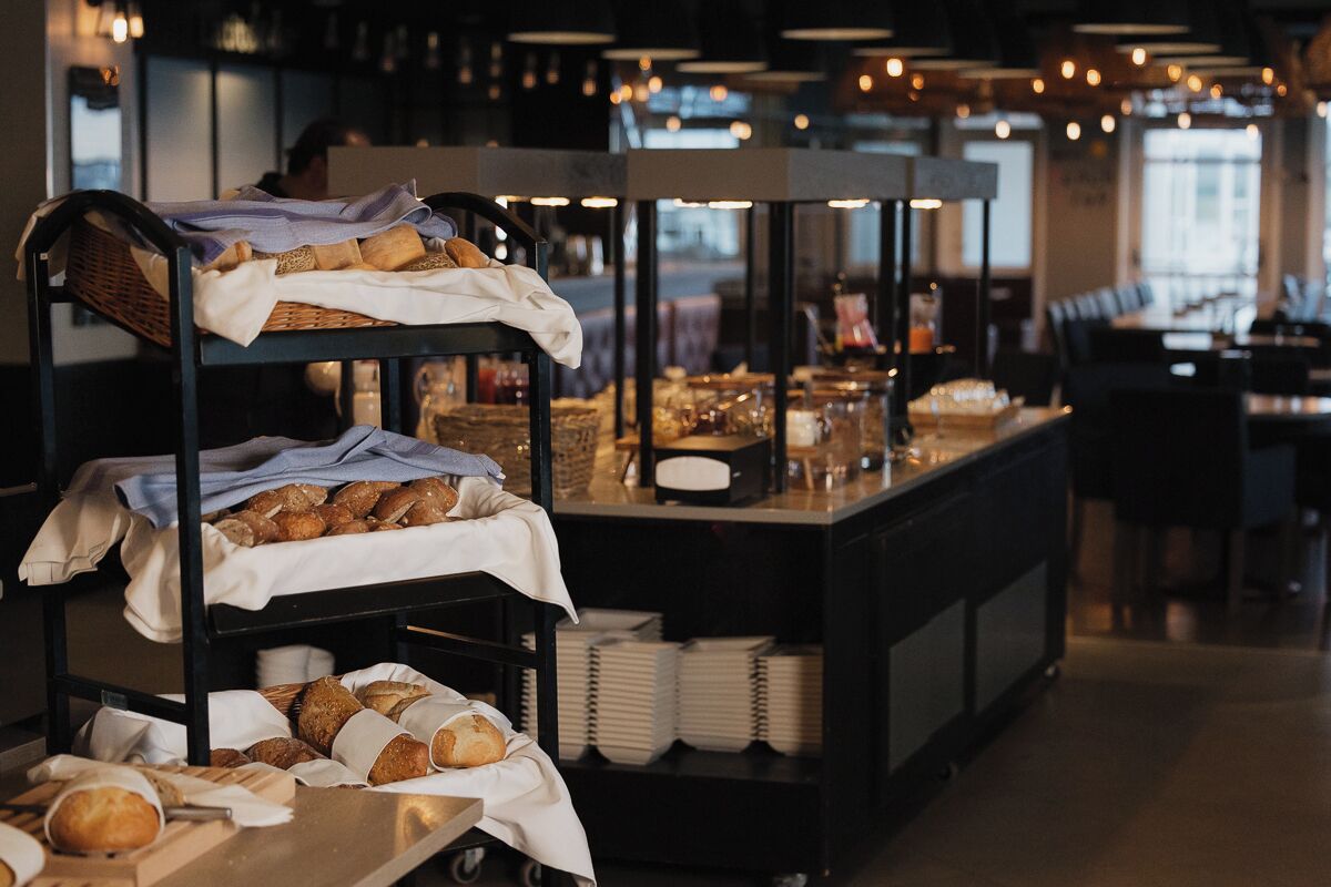 A buffet setup with bread and pastries on display tables.