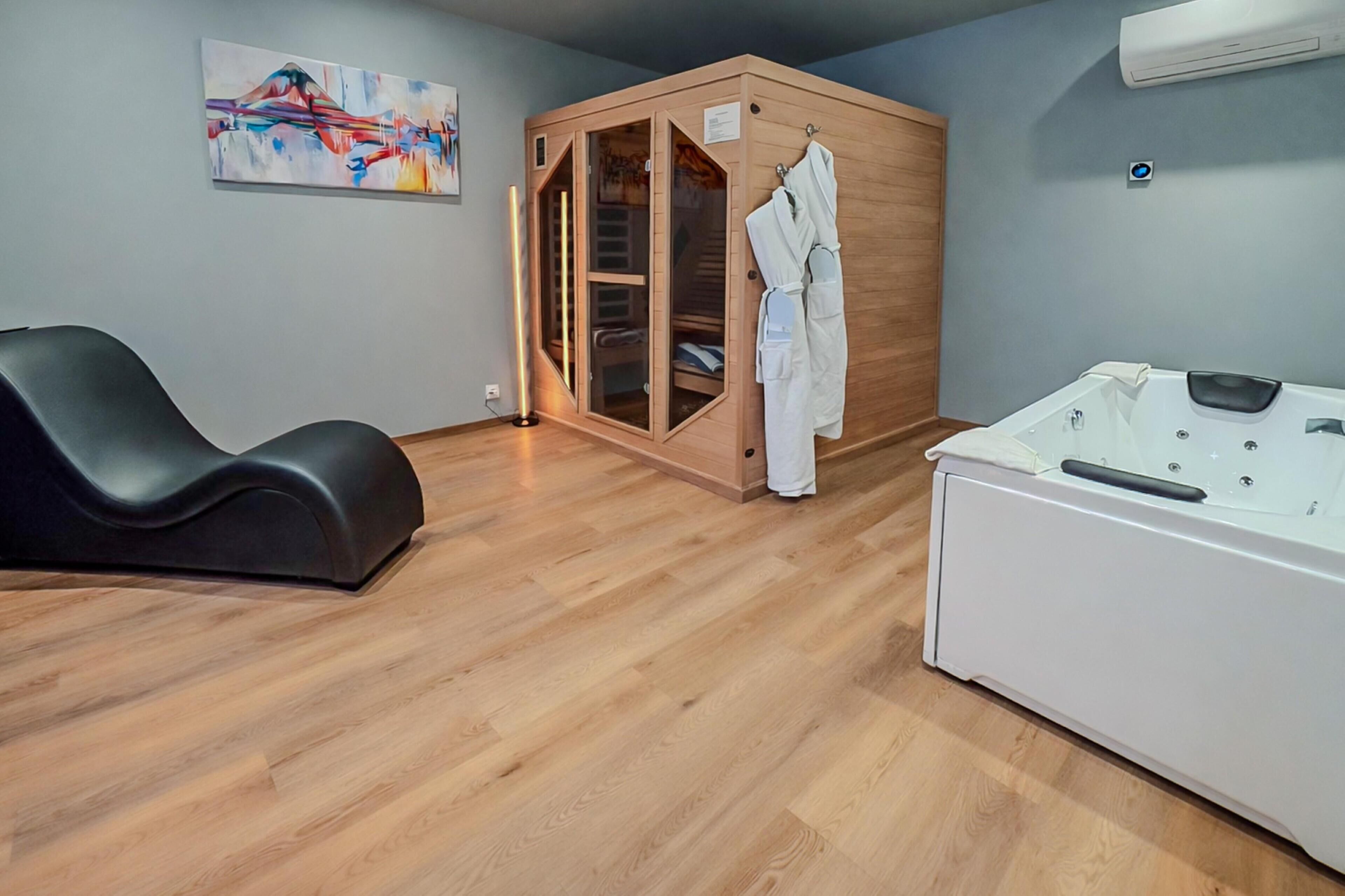 A spa room with a massage chair, a wooden cabinet with glass doors, and a white hot tub.