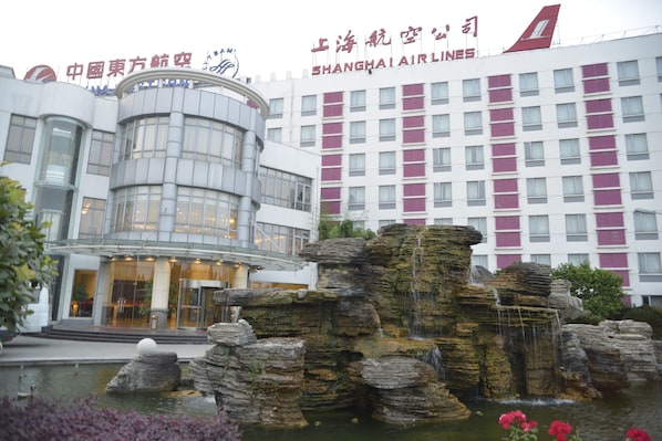 A modern building with a large water feature in front.