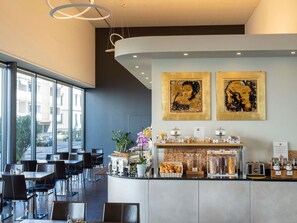 A modern cafe with a curved counter, seating area, and large windows.