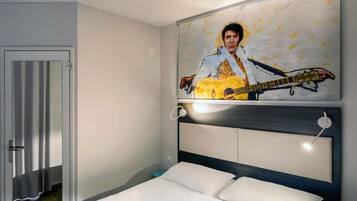 Un dormitorio con cama, cabecera, cuadro colgado en la pared de una guitarra y una puerta.