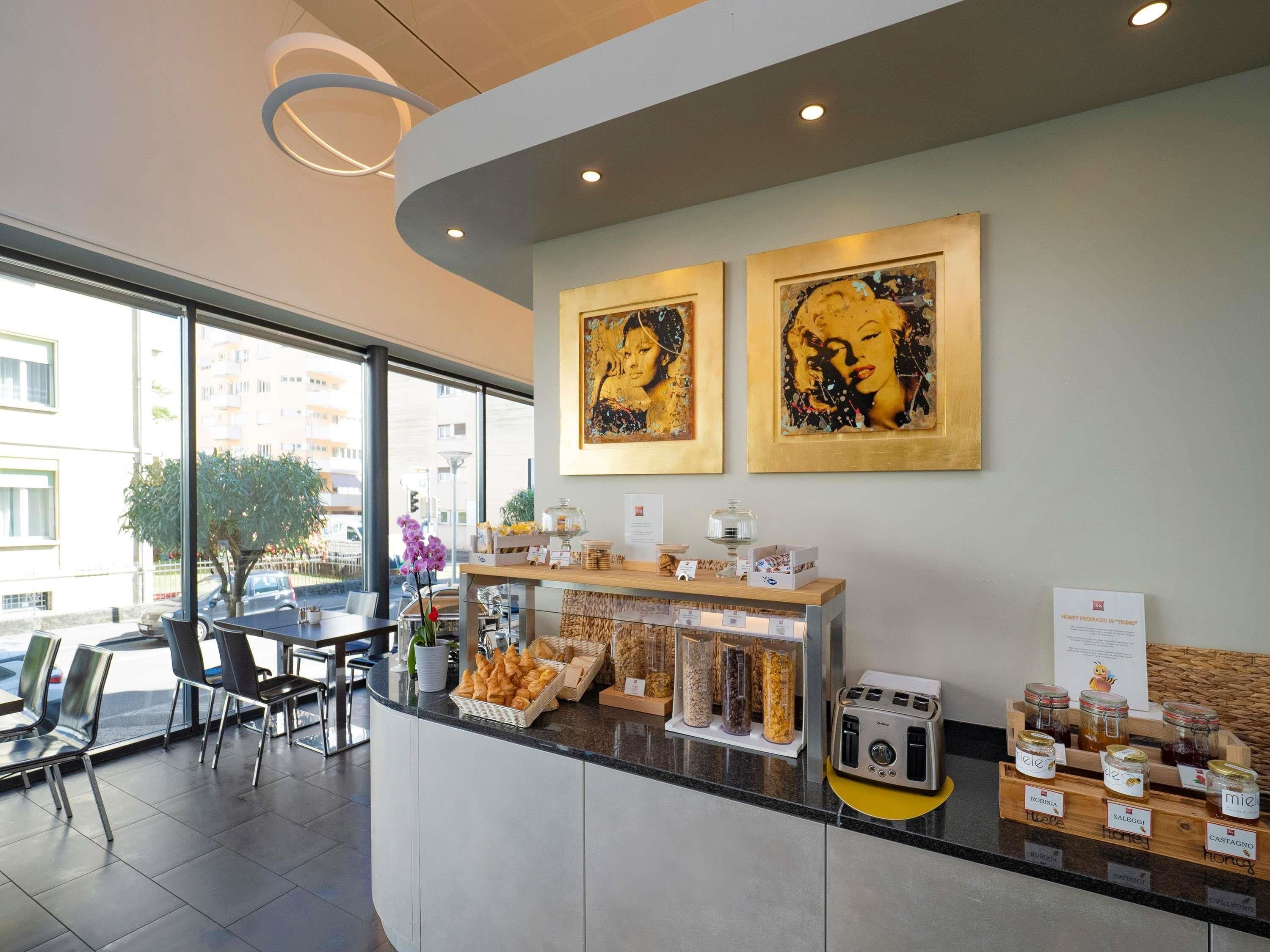 A modern reception area with a counter displaying pastries and condiments, a toaster, and framed artwork on the wall.
