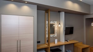 Ein modernes Badezimmer mit einem Holzbadschränken, einem großen Spiegel und Einbauleuchten.