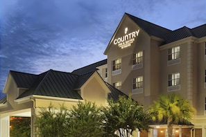 A Country Inn & Suites building with a dark roof, multiple windows, and a sign indicating it is a hotel.