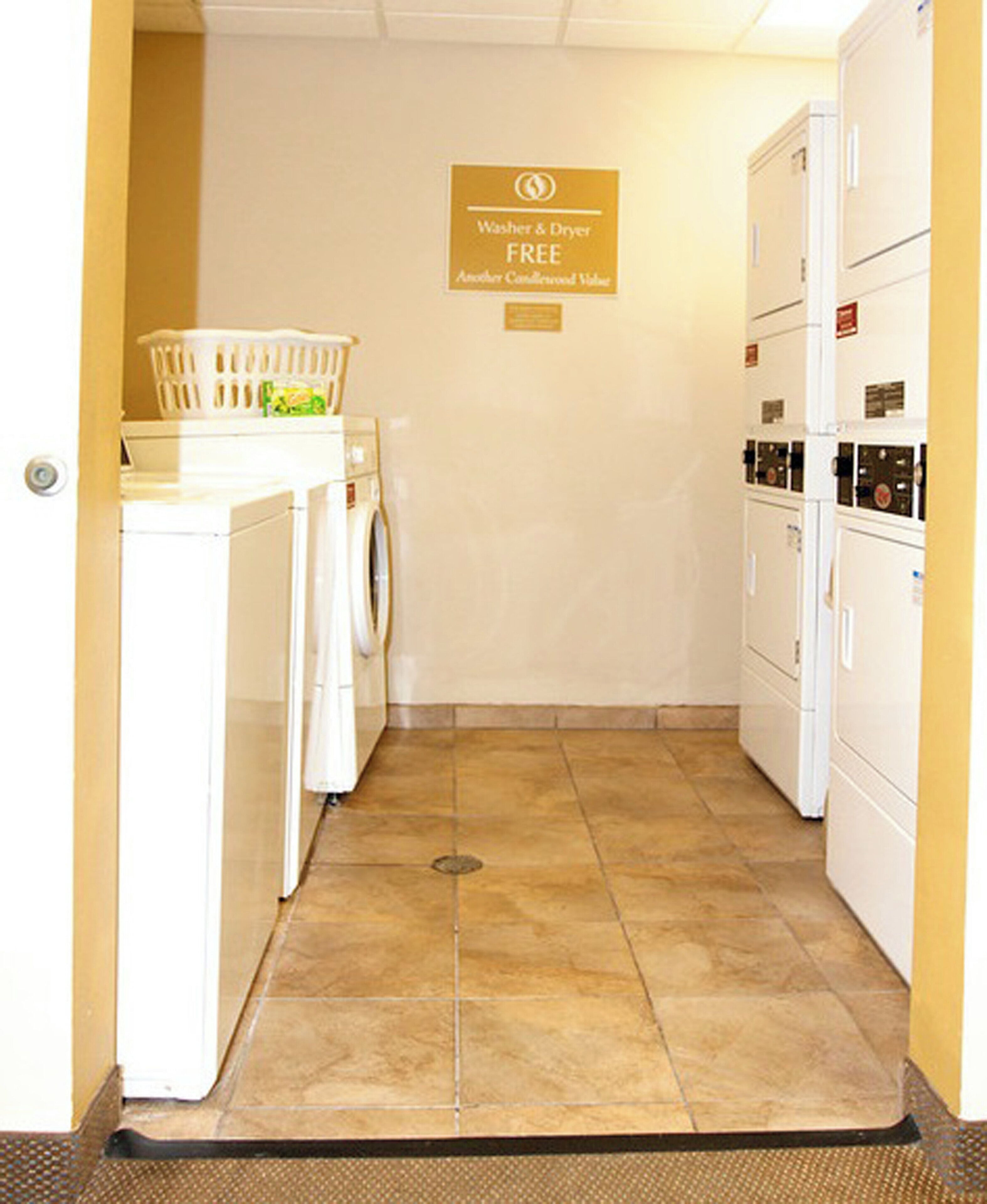 A laundry room with a washing machine, dryer, and a sign indicating free washer and dryer use.