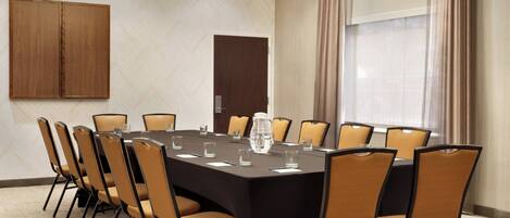 A conference room with a large table, chairs, and a water pitcher.