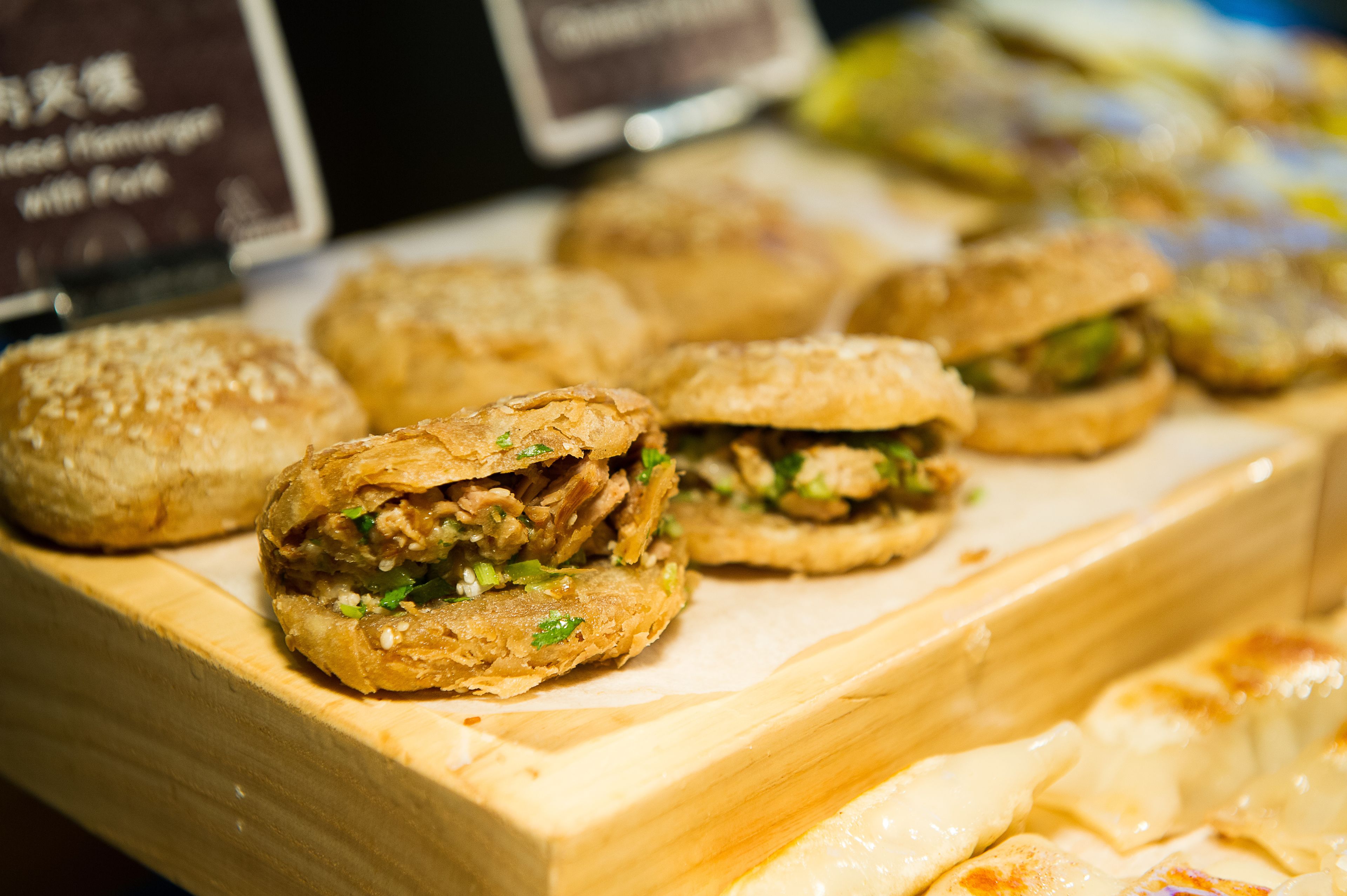 A display of food items, specifically sandwiches, on a wooden board.