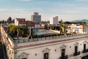 A historic building with a central courtyard, a fountain, and a view of the cityscape. - Casa Pedro Loza (Guadalajara)