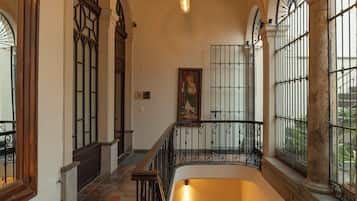 A staircase with a wooden handrail and black metal balusters, leading to a lower level.