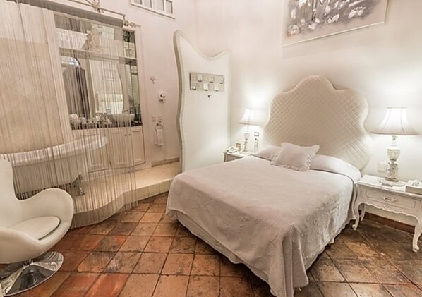 A bedroom with a large bed, a chair, a nightstand, and a wardrobe. - Casa Pedro Loza (Guadalajara)