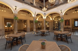 A spacious indoor area with multiple seating arrangements and a checkered floor pattern. - Casa Pedro Loza (Guadalajara)