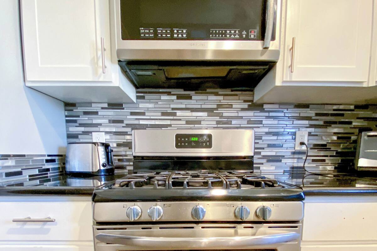 A kitchen with a stainless steel stove, oven, and microwave.