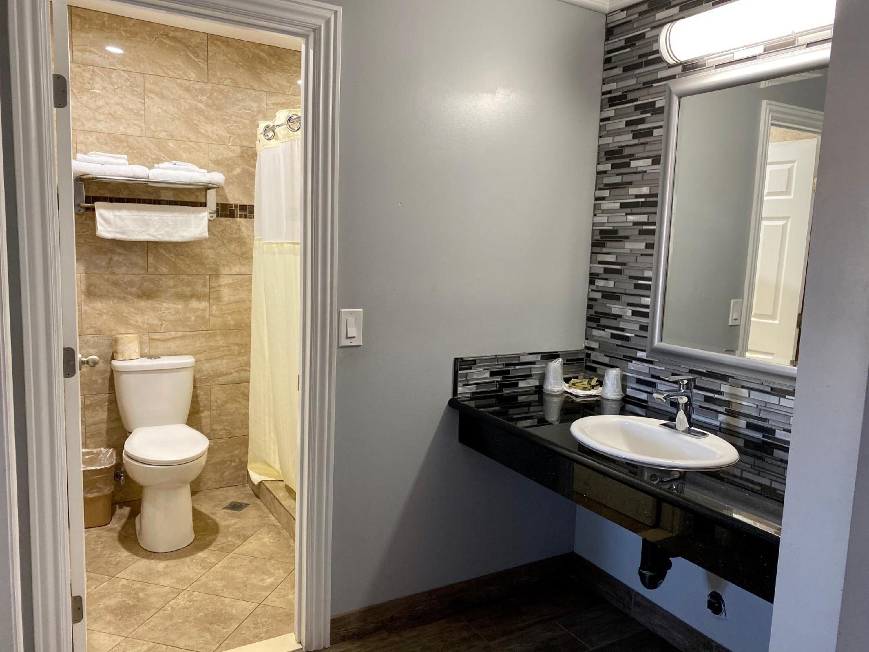 A modern bathroom with a toilet, sink, and shower.