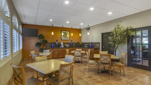 A restaurant with wooden tables and chairs, a tiled floor, and a large window with blinds. - Best Western Copper Hills Inn (Globe)