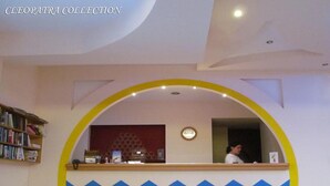 Un espace d’accueil doté d’une arche circulaire, d’un comptoir de réception, d’une horloge et d’une bibliothèque.
