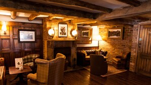 A cozy room with wooden walls, a fireplace, and several seating areas including a sofa and armchairs. - Red Lion Todwick by Chef and Brewer Collection (Sheffield)