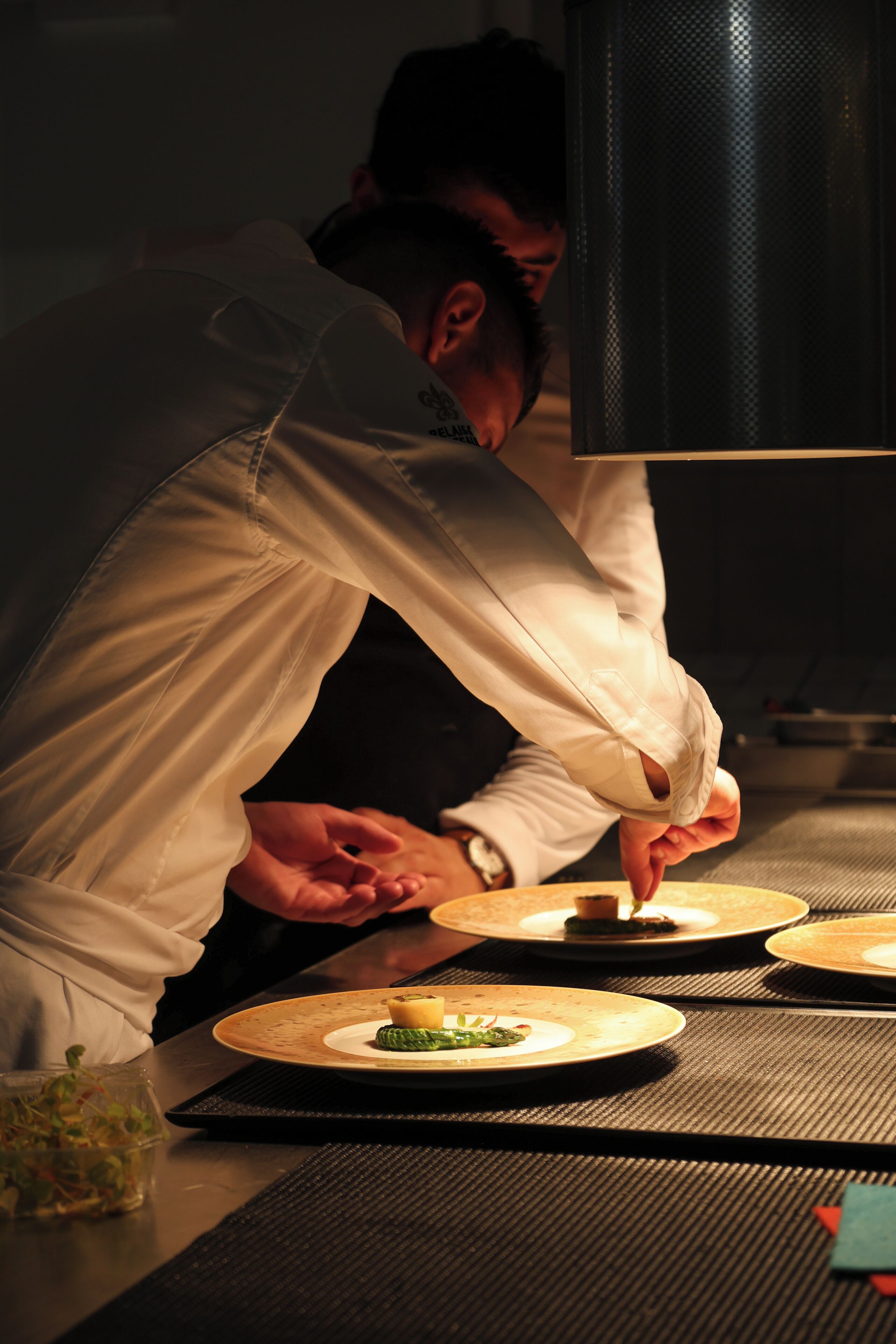 A person in a white shirt preparing food on a table with a woven placemat.