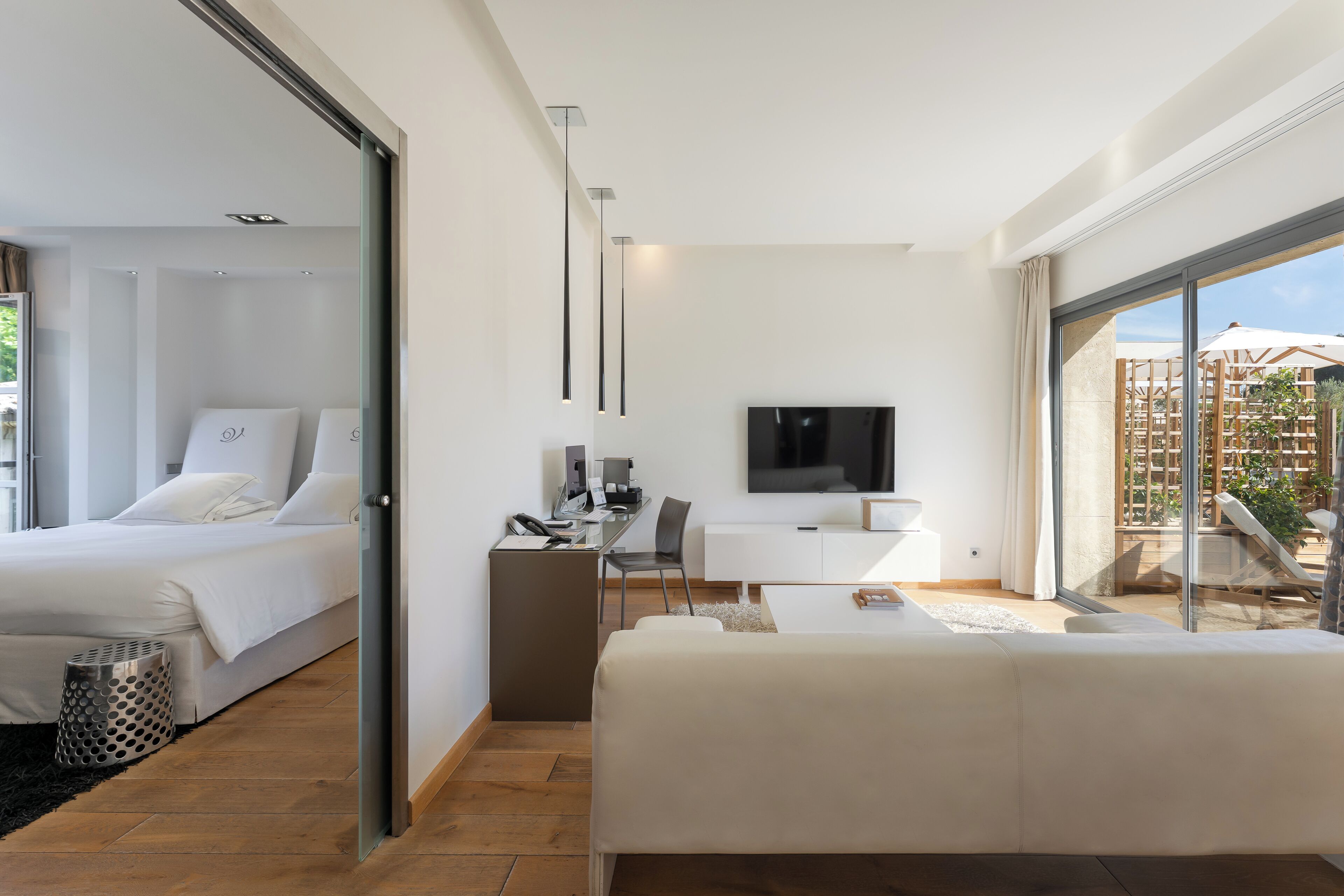 Een moderne hotelkamer met een bed, bureau en televisie.