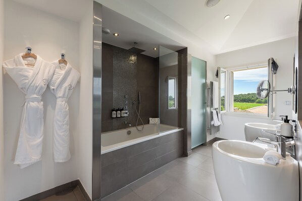 A modern bathroom with a large bathtub, a separate shower area, and a vanity with a sink.
