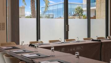 A conference room with a long table, chairs, and water glasses.