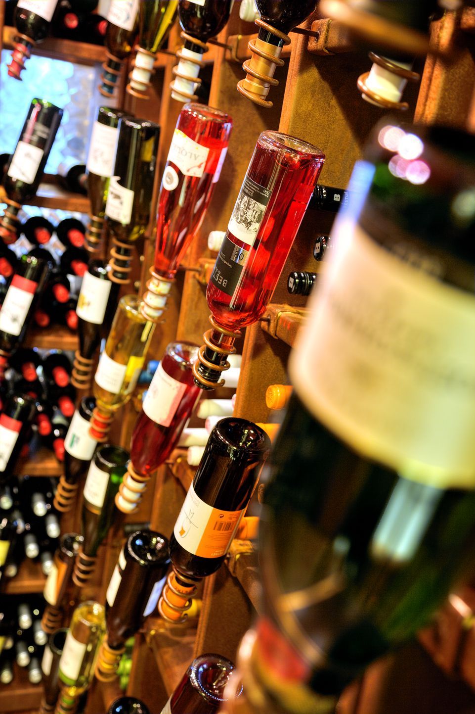 Variedad de botellas de vino dispuestas en estantes en un bar.