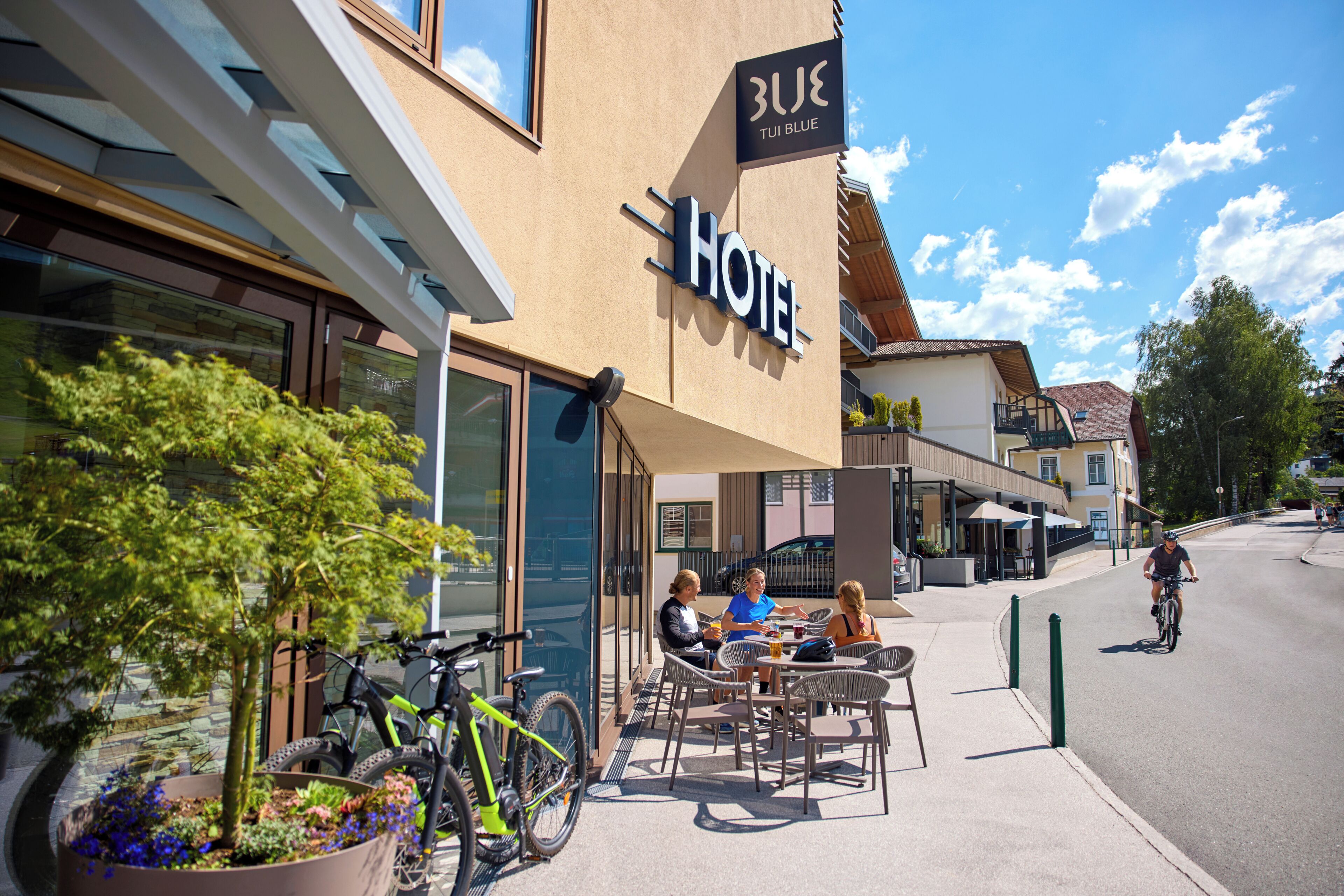 A hotel with outdoor seating and a bicycle parked outside.