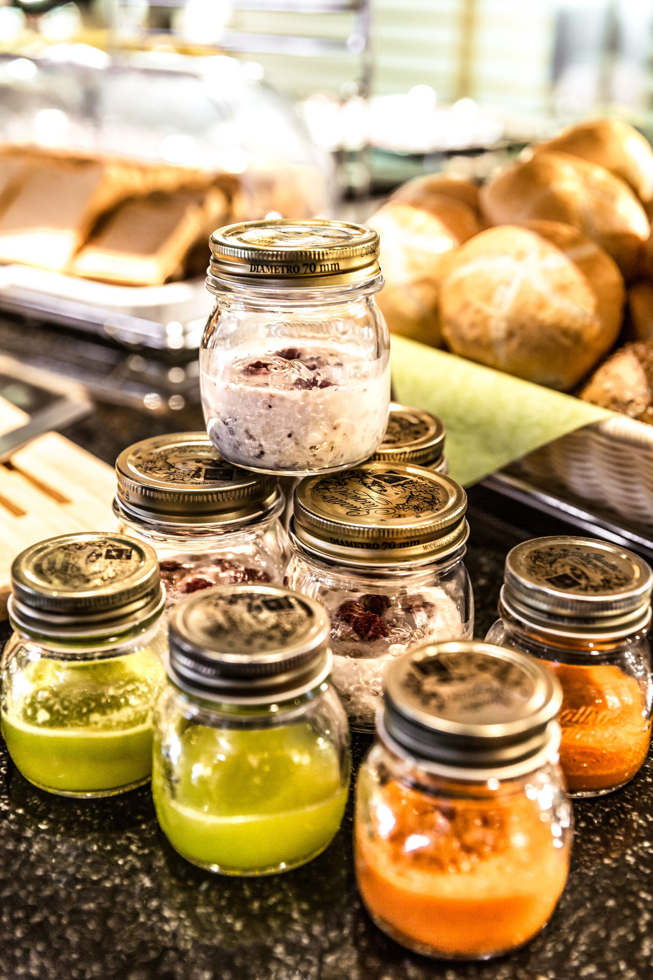 A variety of jars with different colored contents, possibly condiments, arranged on a countertop.