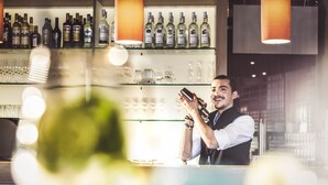 Eine Bar mit Regalen voller Spirituosenflaschen und Gläsern.